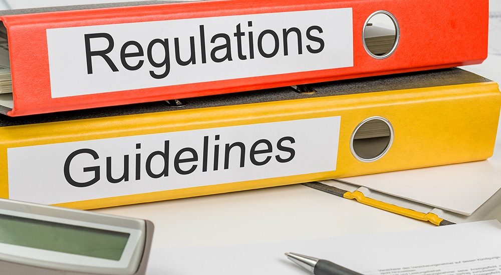 two binders that say 'regulations' and 'guidelines'