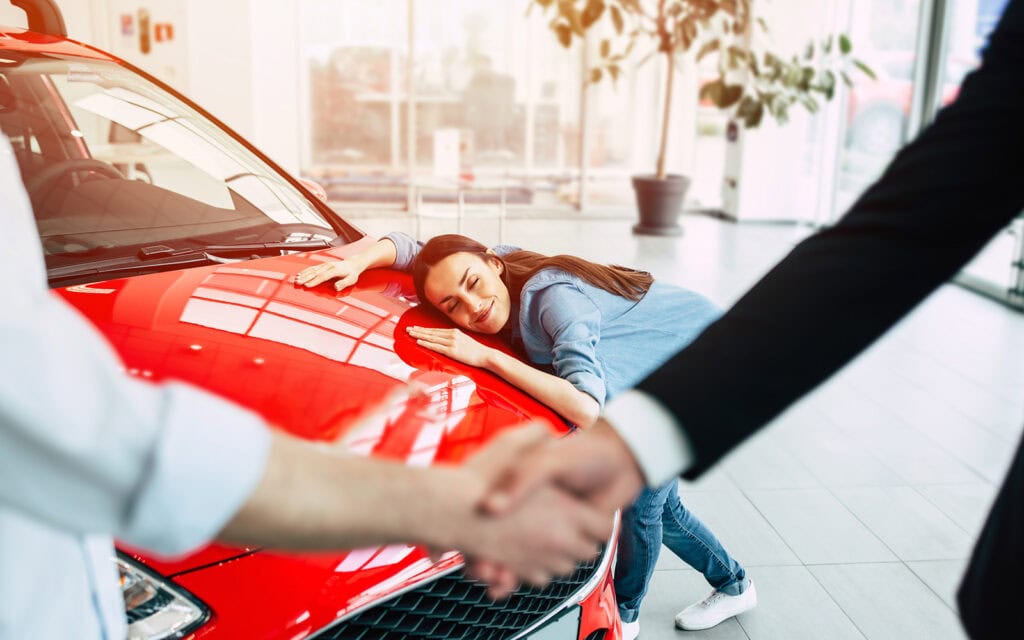a woman hugging her new car that she got with with a car loan