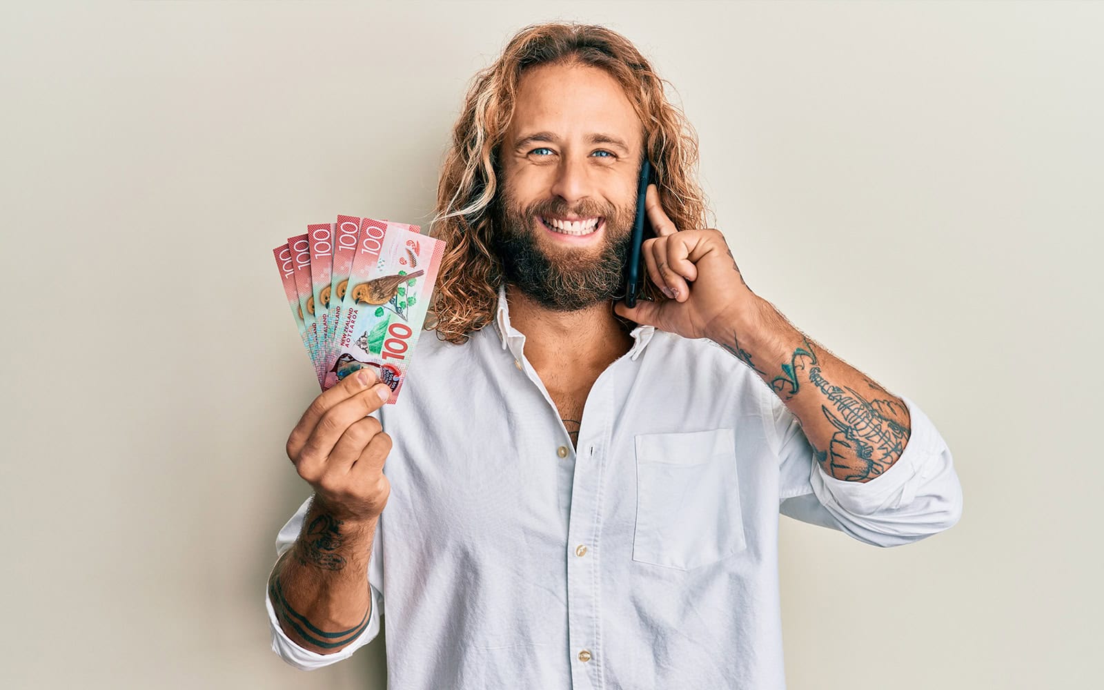 a man on the phone holding up cash from a quick loan