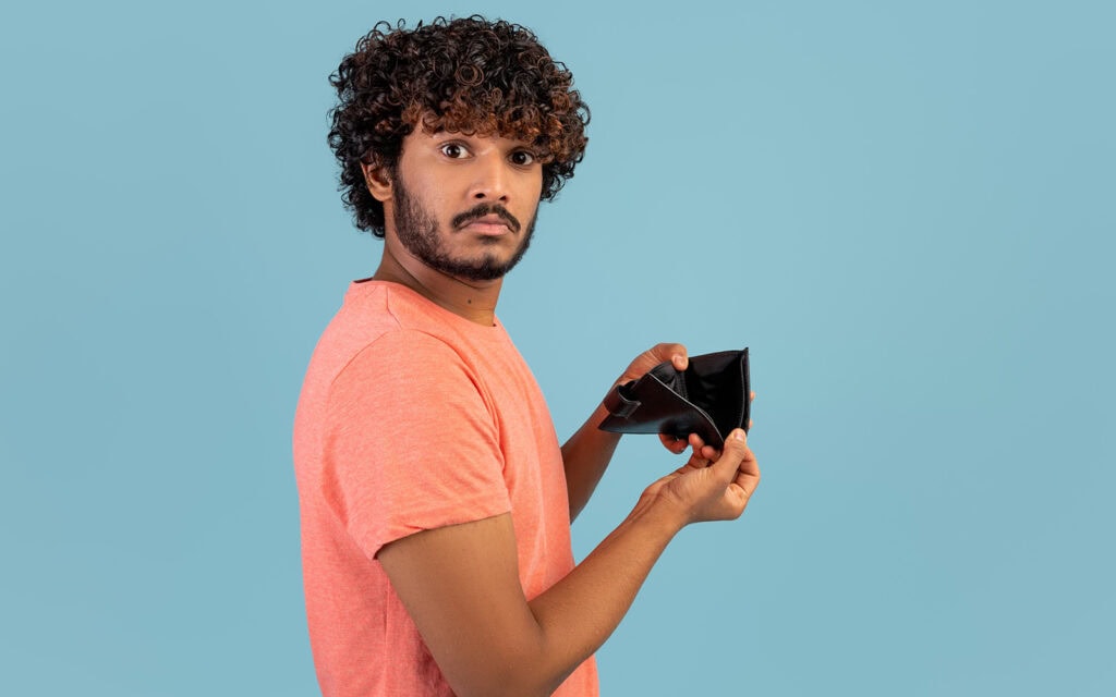 a guy showing his empty wallet, in need of a cash loan