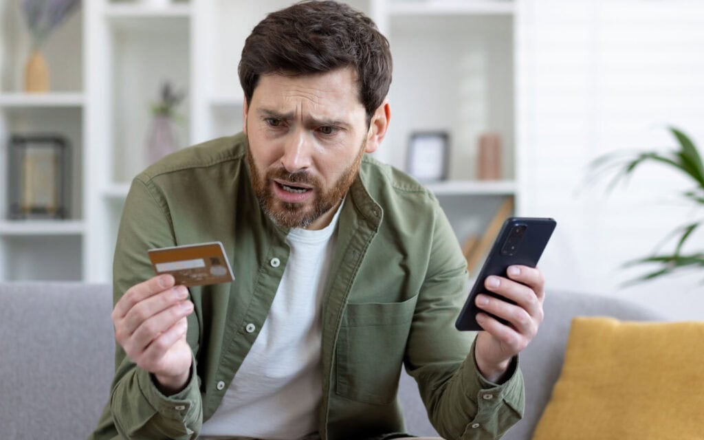 A man frustrated looking at his credit card debt