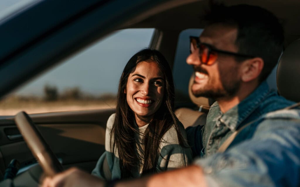 A couple in their new car that they purchased with a secured car loan