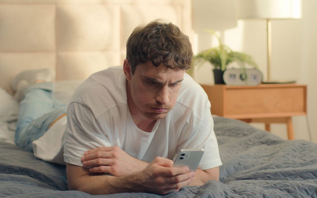 A guy looking at his bad credit score on his cell phone