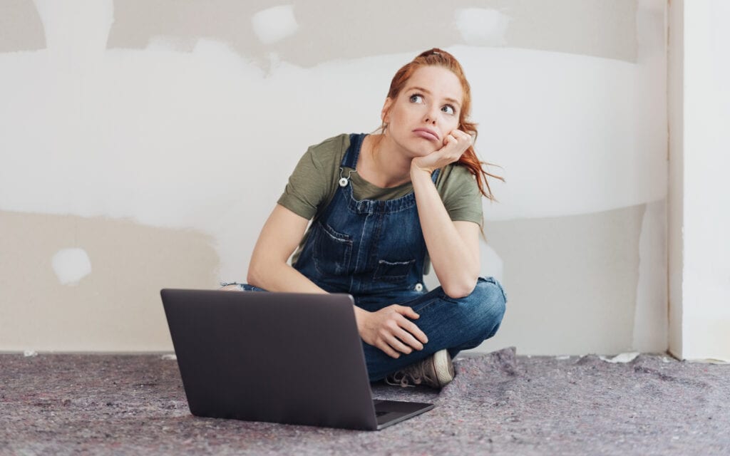 a woman sitting on the floor with her laptop