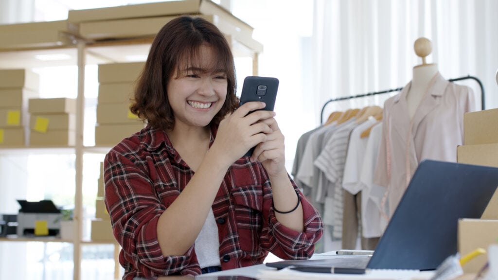 Happy Kiwi woman on the phone chatting about responsible lending and emergency loans with Auckland Loans.