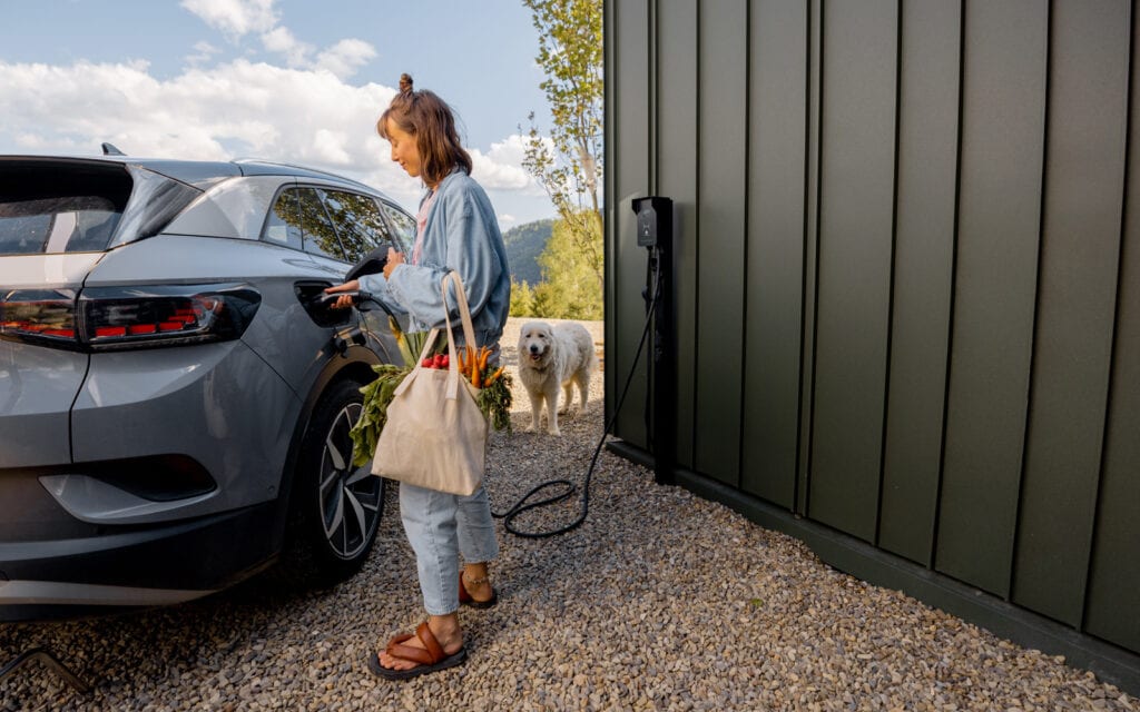 Young woman charging electric vehicle
