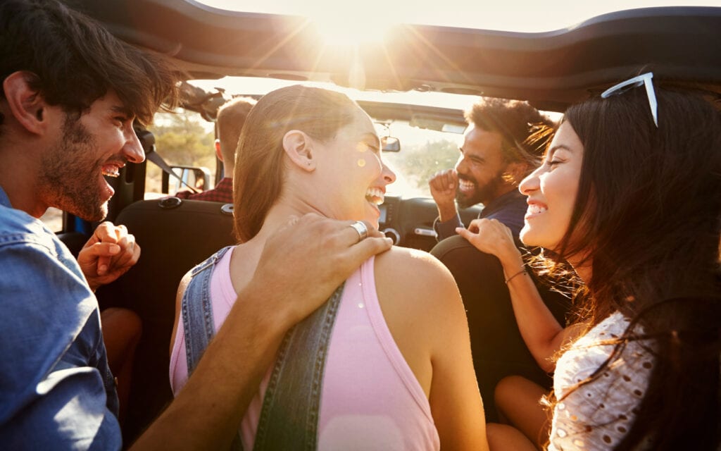 Group of friends laughing during a road trip made possible with an Auckland Loans - weekend loan!