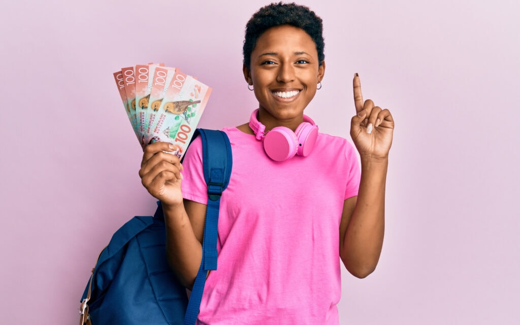 Smiling woman holding NZD bills after receiving fast weekend loan approval from Auckland Loans.